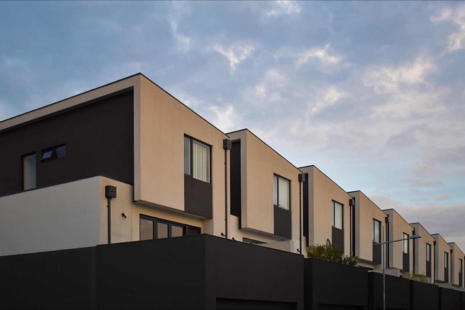 Placeholder photograph of a modern render-and-brick townhouse development