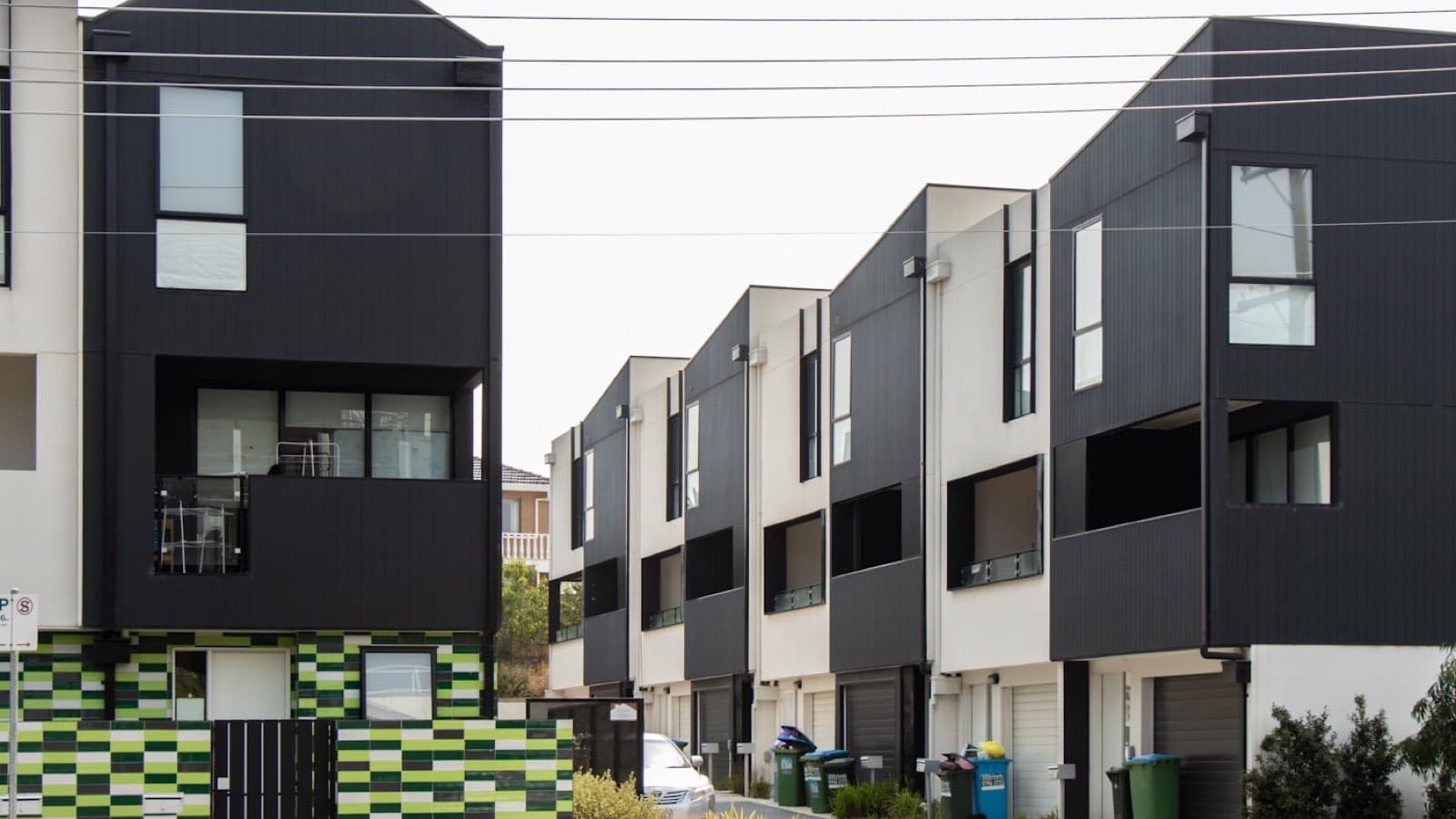 A row of dark-clad modern townhouses