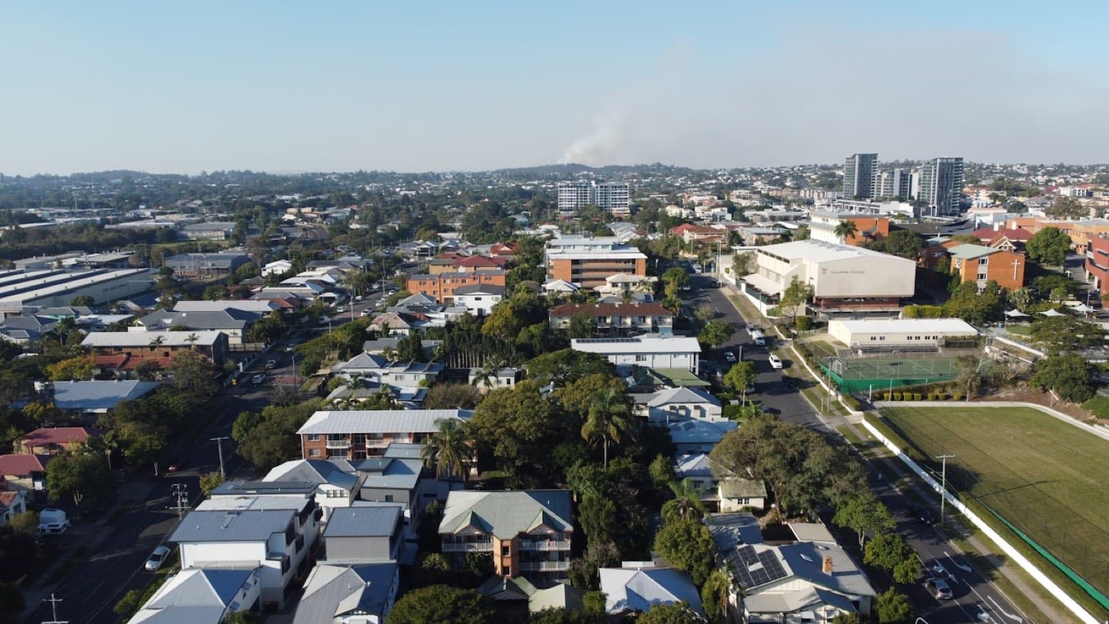 Aerial view of suburban rooftops with hills beyond