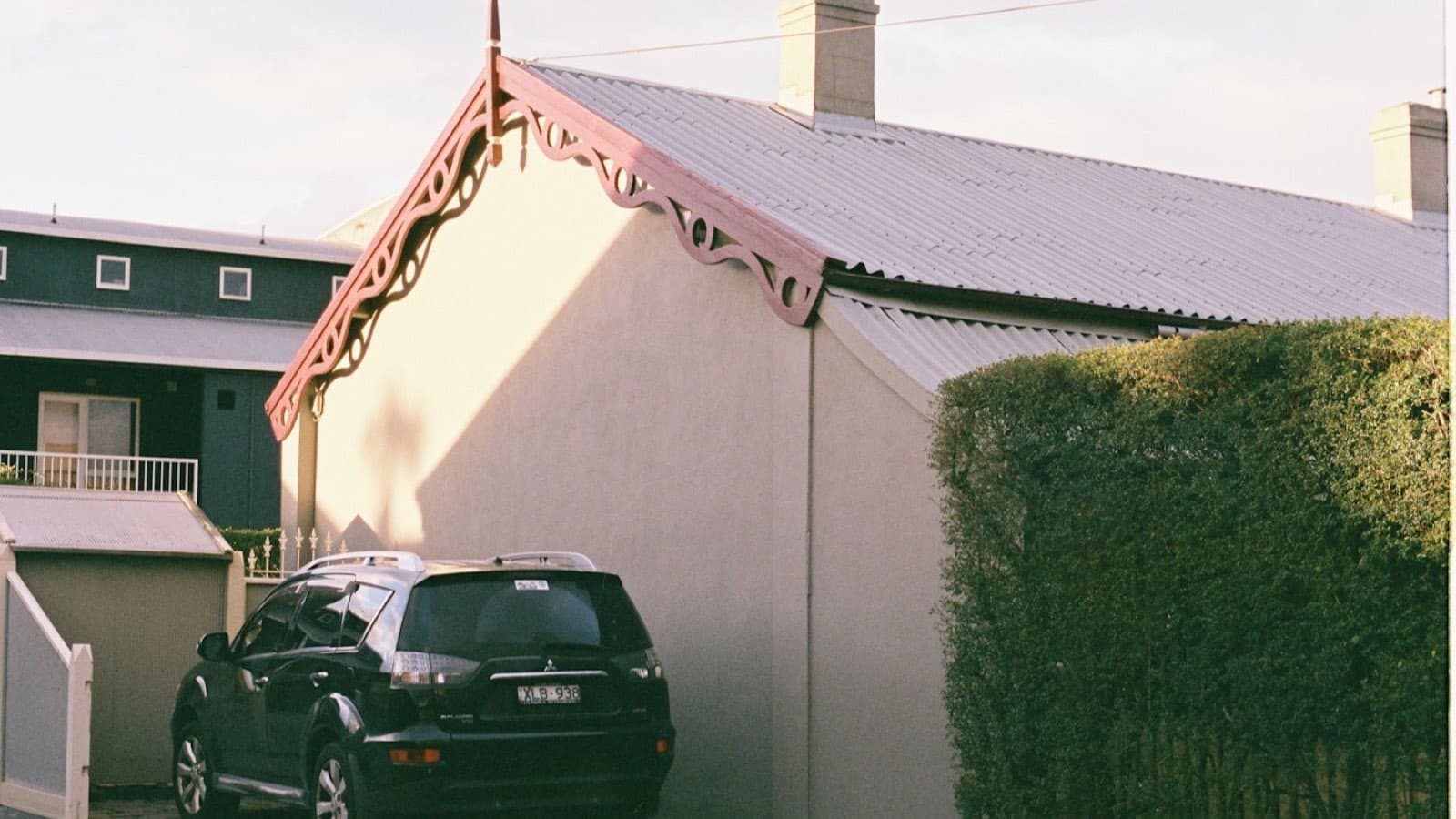 A hatchback parked beside a white rendered house